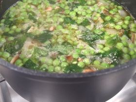 Peas cooking with parsley and pancetta